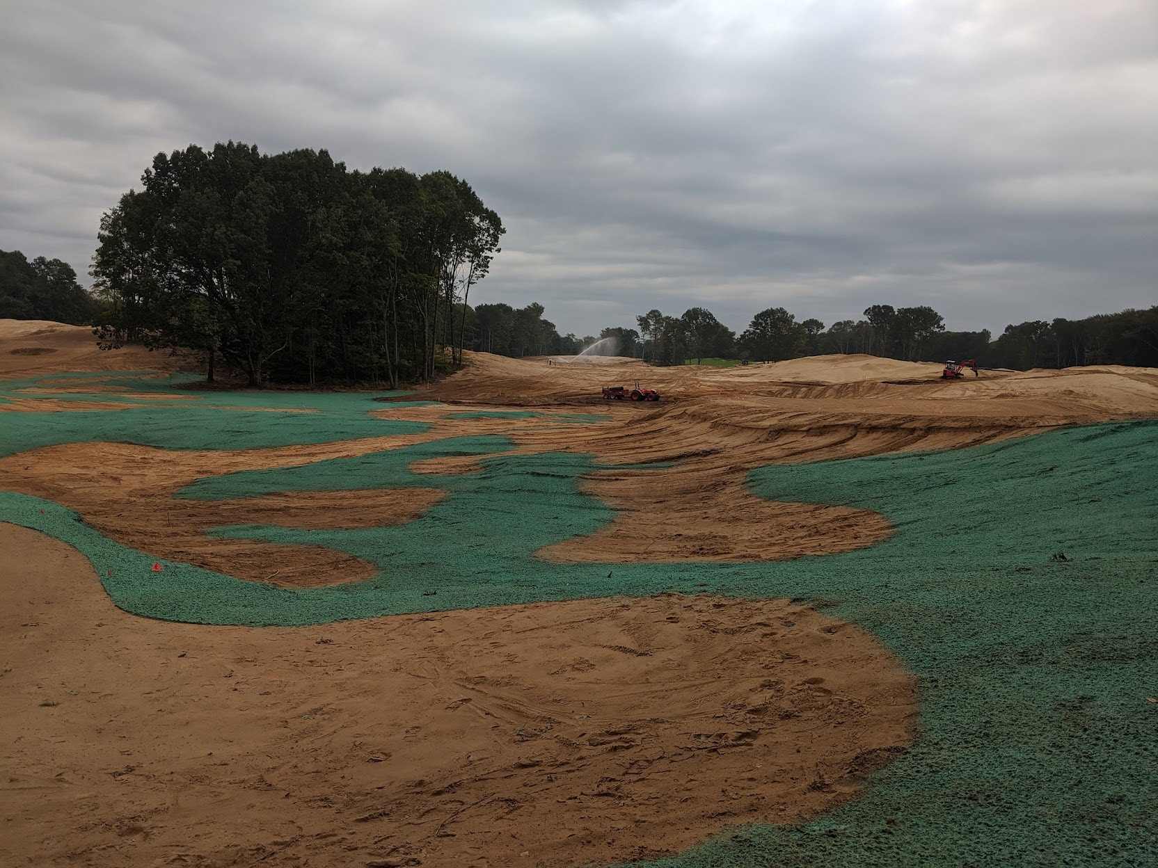 Hydromulch coverage in winding patterns across fairway and bunkers at American Dunes golf course
