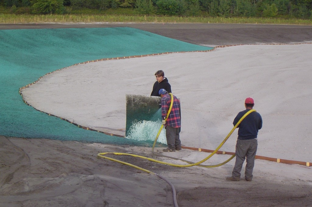 Workers applying hydroseed at Macatawa Legends golf course